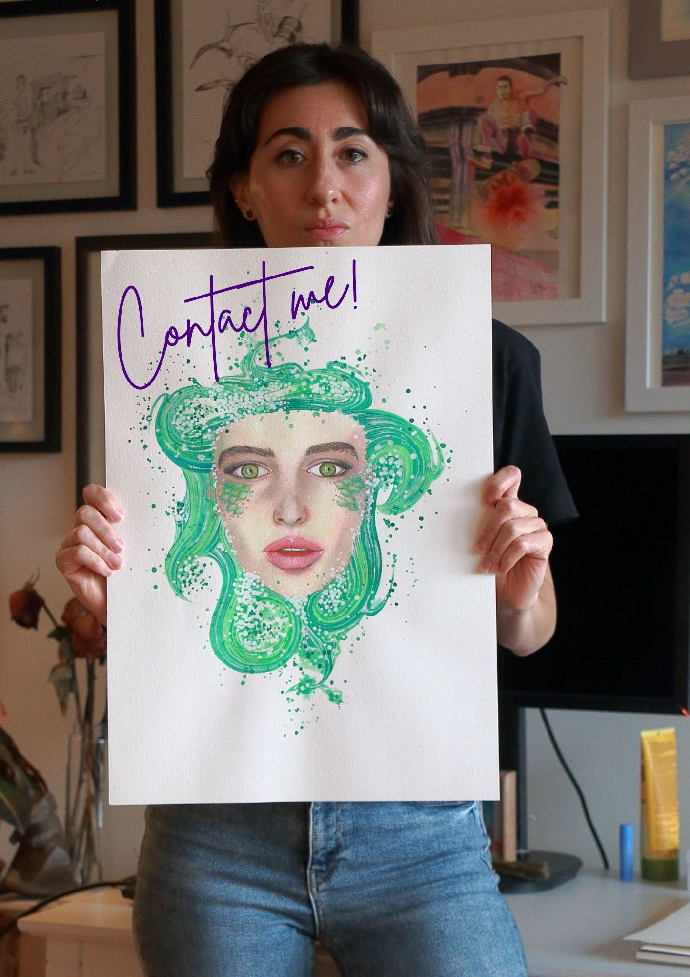 Paula Di Marco holds a surrealist watercolor print of a green-haired woman with expressive eyes and soft pink lips. The emotionally charged artwork features the words “Contact me!” and reflects Paula’s signature style—blending emotional expression, mysticism, and surrealist storytelling in fine wall art.