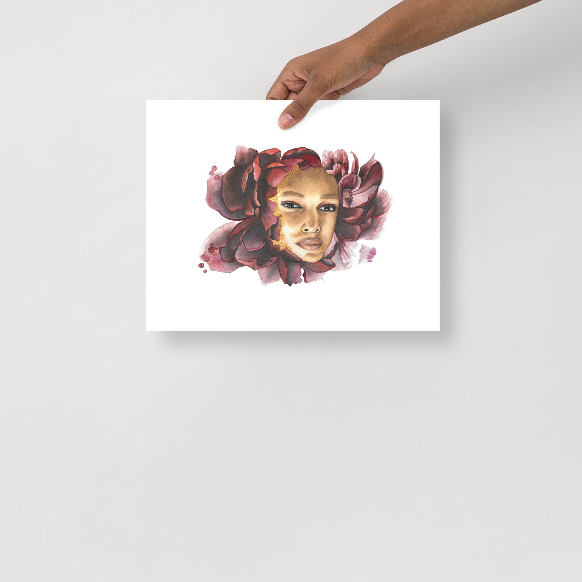 Pensive Bloom by Paula Di Marco – 11x14 inch giclée fine art print featuring a contemplative face surrounded by deep crimson petals. Displayed unframed in a minimal setting to highlight the artwork's emotional depth and delicate watercolor details.