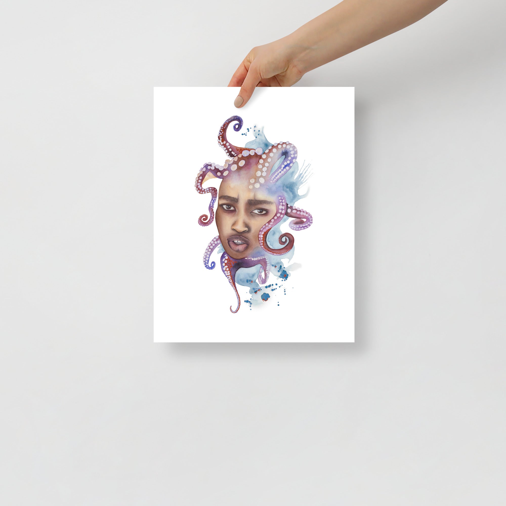 Framed surrealist watercolor art print of woman with octopus hair, held by hand for scale