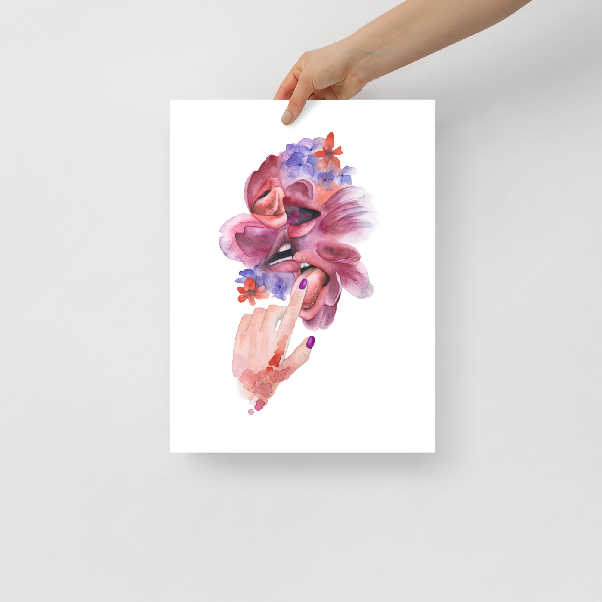 Hand holding a giclée art print of Paula Di Marco’s surreal watercolor painting ‘Make Out Session,’ a sensual and emotionally charged composition featuring expressive mouths and vibrant florals