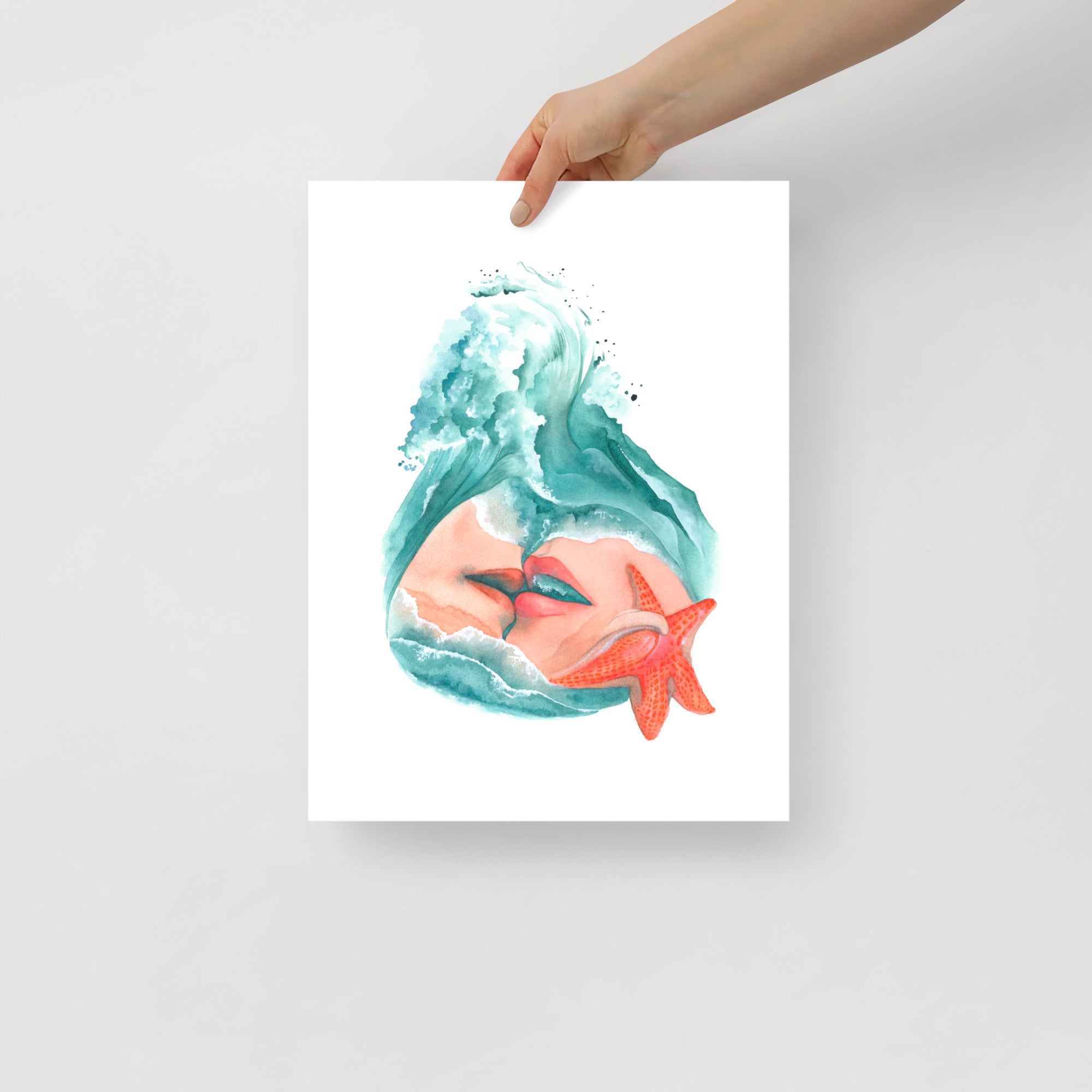 Hand holding a 12x16 surrealist watercolor art print of two lovers kissing under ocean waves with a starfish — emotionally charged artwork by Paula Di Marco from the Playful Awakening collection