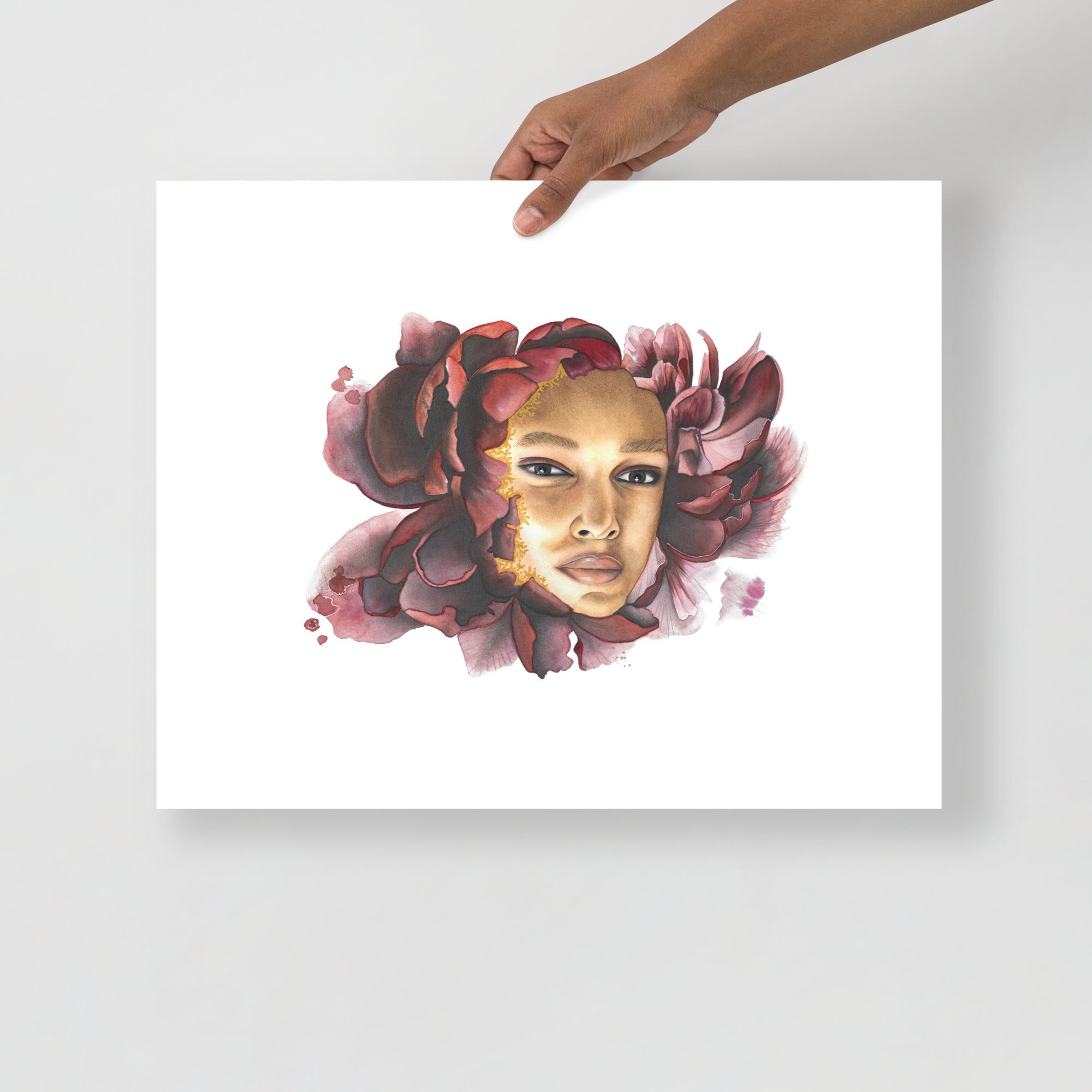 Pensive Bloom by Paula Di Marco – 16x20 inch giclée art print on archival paper. This piece features a meditative female portrait framed by rich burgundy petals, symbolizing quiet strength and inner radiance. Unframed, shown in hand for scale.
