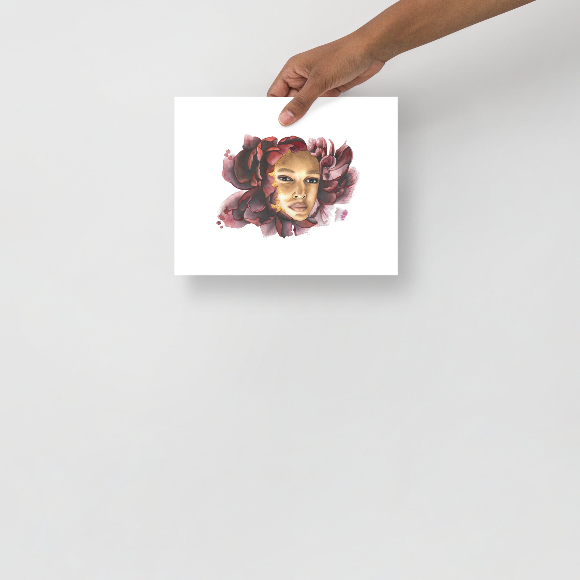 Pensive Bloom by Paula Di Marco – 8x10 inch giclée fine art print featuring a contemplative face surrounded by deep crimson petals. Displayed unframed in a minimal setting to highlight the artwork's emotional depth and delicate watercolor details.