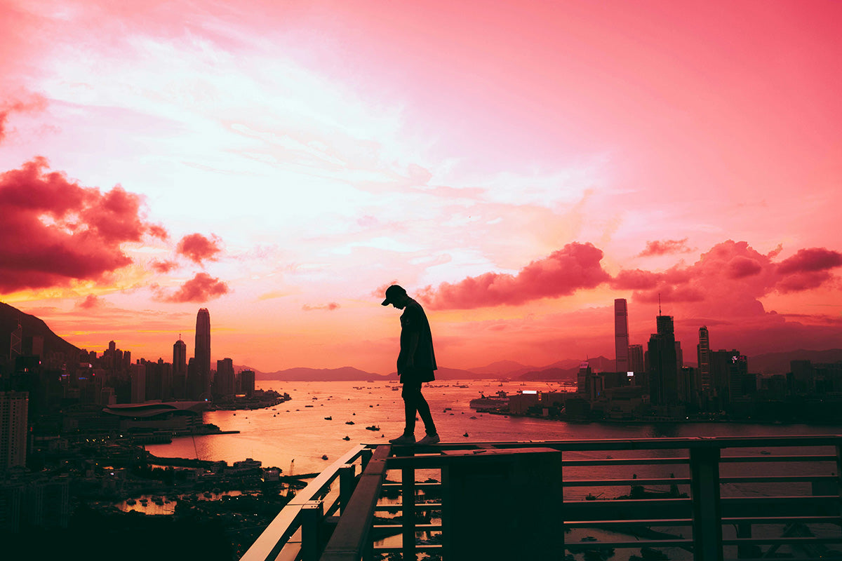 Man walking on railing at sunset