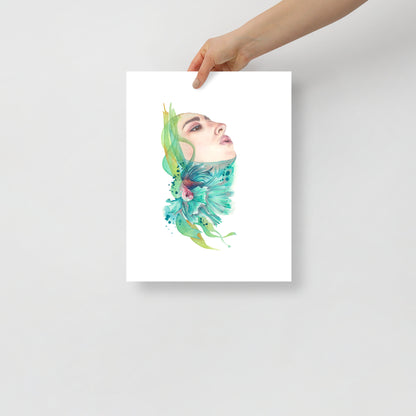 Woman holding a giclée 11x14 art print titled A Breath of Air by Paula Di Marco – featuring a serene female face, flowing seaweed, and a teal betta fish. Part of the Divine Feminine collection. Printed on archival-quality matte paper.